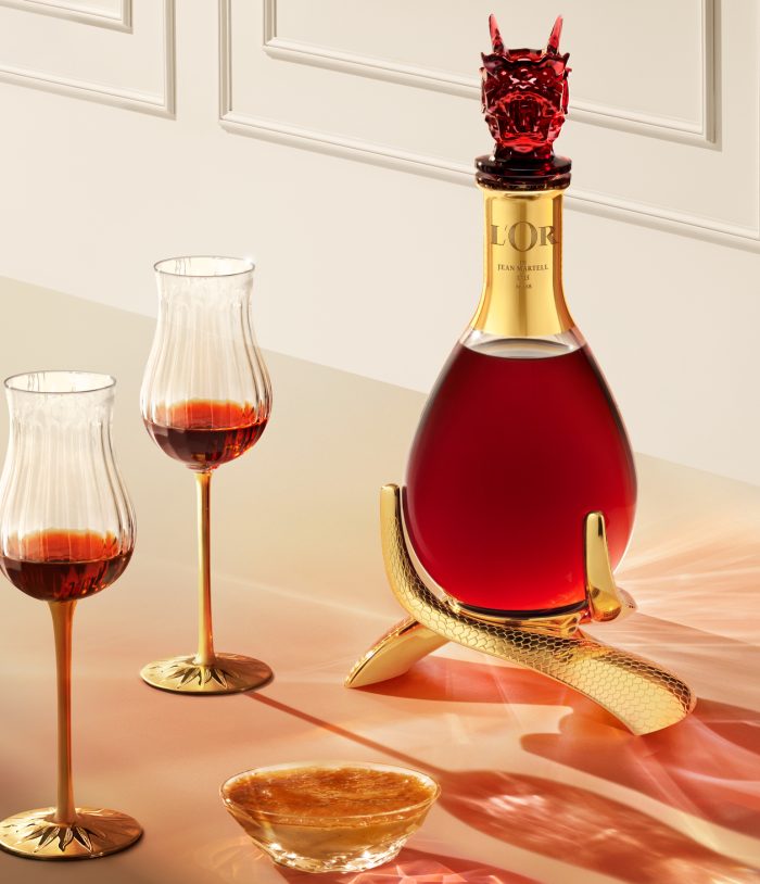 Visual of the bottle L'Or de Jean Martell - Zodiac Edition L'Assemblage du Dragon with two glasses on a table