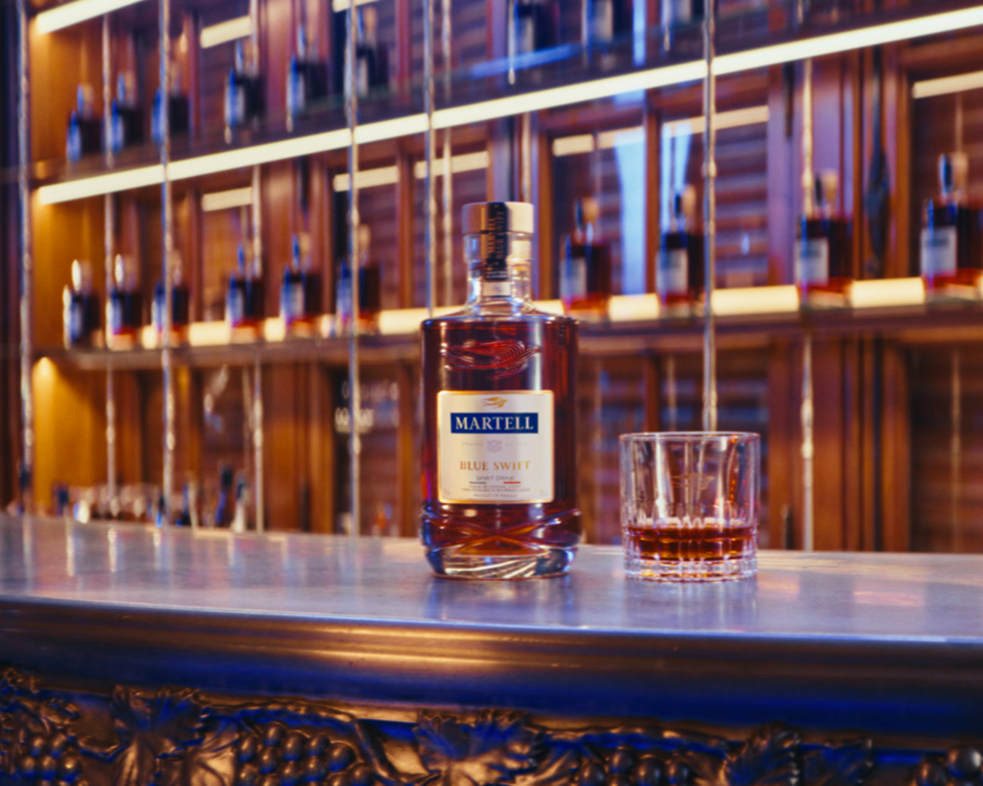 Bottle of Martell Blue Swift with a glass on a bar
